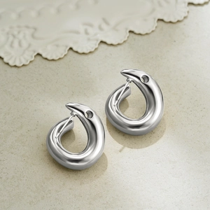 Detailed view of silver fluid teardrop earrings with a polished metallic finish