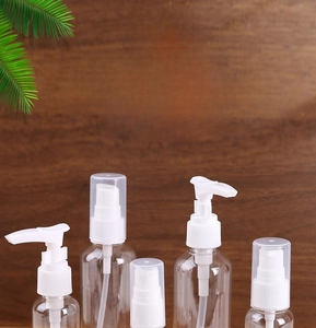 Detailed view of clear PET lotion bottles with pump and spray heads on wood background