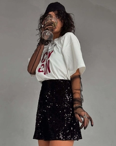 Détail du t-shirt blanc en coton avec imprimé rouge et jupe à paillettes noire