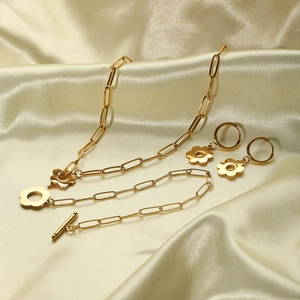 Elegant 18k gold plated stainless steel flower jewelry set on champagne silk fabric