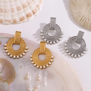 Detail view of vintage gold and silver concentric hoop earrings with white pearls