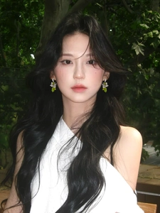 Close-up of elegant flower crystal drop earrings worn by a model in a natural setting