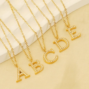 Macro view of gold plated A-E letter pendants with shimmering zircon micro-inlay