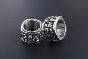 Macro shot of oversized titanium steel rings with intricate vintage gothic relief patterns