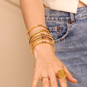 Fashionable gold bangle set with star etching and sparkling zircon on model wrist