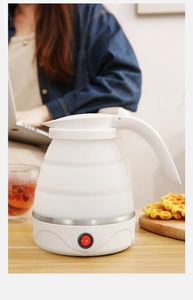 Portable white silicone foldable electric kettle on a wooden table for home office