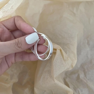 Minimalist high-polished S925 sterling silver hoop earrings held by hand