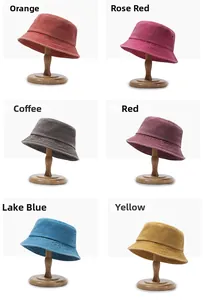 Detail view of corduroy bucket hats in six colors with metallic eyelets on wood stands