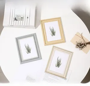 Detailed view of ivory and gold minimalist photo frames with elegant floral art