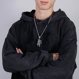 Gros plan d'un collier pendentif Pharaon argenté avec chaîne torsadée sur un mannequin