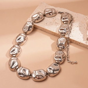 Detailed view of chunky silver textured necklace with abstract geometric metal pieces