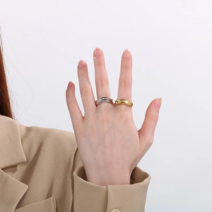 Dettaglio degli anelli plissettati irregolari in oro e argento indossati da una modella