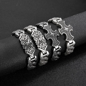Vintage gothic style stainless steel bracelets with embossed patterns on a black display