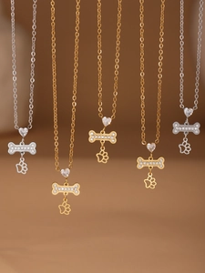 Detail van gouden en zilveren puppy bot kettingen met strass poot en hart hangers
