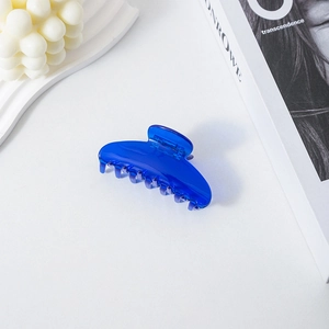Close-up of a royal blue translucent acetate hair claw clip on a white surface.