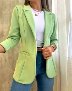 Primer plano de un elegante blazer verde claro para mujer con solapas y manga larga