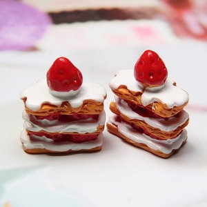 Detailed view of two miniature resin strawberry mille-feuille cakes for DIY crafts