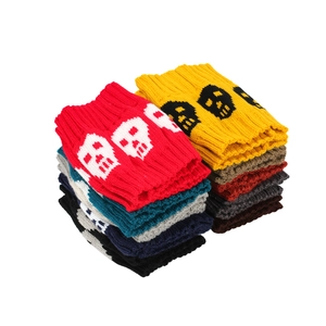 Detailed stack of knit leg warmers with skull patterns in various vibrant colors