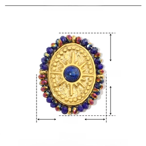 Detail of round gold stainless steel pendant with blue natural stone and purple beads