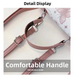 Detail of pink PU leather strap with silver metal buckle on butterfly patterned handbag