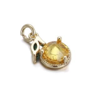 Detail of 14k gold-plated jewelry pendant featuring a yellow gemstone and green leaf
