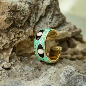 Close-up of mint green evil eye enamel open ring on a natural stone background