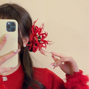 Macro detail of red Lycoris Radiata hair clip worn on a side bun hairstyle