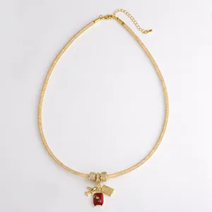 Gouden mesh ketting met hangers van een vliegtuig, koffer en wereldbol voor reisliefhebbers