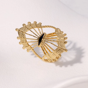 Detailed view of vintage gold hollow sunburst ring with black oval center stone