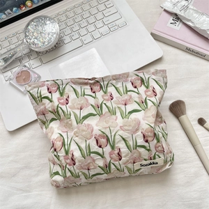 Gros plan de la trousse de maquillage en coton matelassé avec imprimés tulipes roses