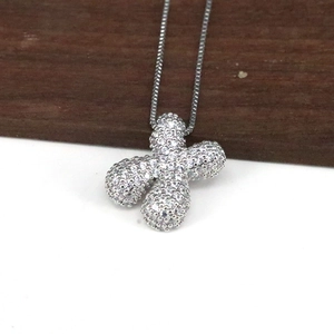 Detailansicht eines silbernen X-Anhängers mit Zirkonia an einer minimalistischen Kette