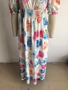Détail de la taille haute élastique et de l'imprimé floral sur une robe d'été à manches bouffantes