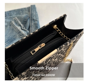 Close-up of the smooth golden zipper and internal compartment of leopard print bag