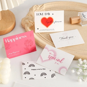 Gros plan de cartes de vœux minimalistes avec motifs de cœurs et fleurs sur un plateau