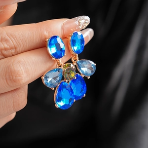 Detailed close-up of vintage geometric waterdrop earrings with blue rhinestones and gold plating
