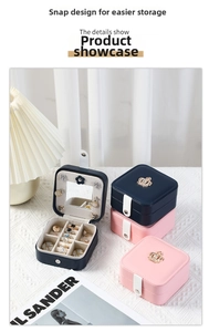 Detailed interior of jewelry box featuring a vanity mirror, ring slots, and crown logo