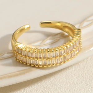 Close-up of golden adjustable ring with double row of rectangular clear cubic zirconia