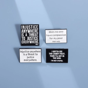 Set of four black and white rectangular enamel pins with motivational English quotes