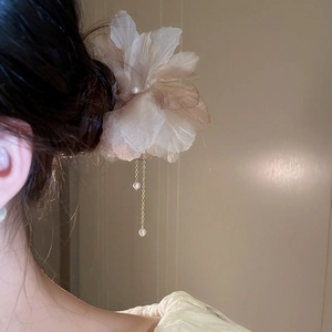 Détail de l'épingle à cheveux fleur en tissu avec pompon perlé et pétales d'organza
