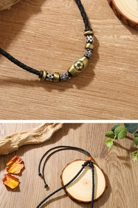 Close-up and layout of vintage braided leather football necklace with brass beads on wood