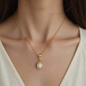 Lussuosa collana in acciaio inossidabile dorato con ciondolo ovale di cristallo su modella