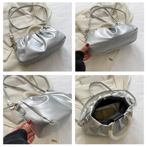 Detail of silver pleated cloud bag with pearl ring handle and metallic PU finish