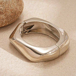 Dettaglio macro del bracciale geometrico argento con cerniera a molla e design cavo