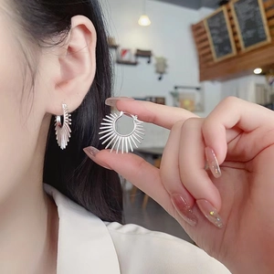 925 Sterling Silver Sun Flower Earrings worn by model in a stylish cafe setting