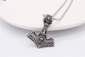 Detailed view of silver Viking Mjolnir pendant with intricate knotwork on snake chain