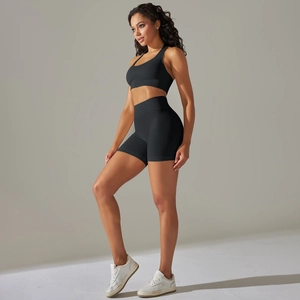 Dettaglio del reggiseno sportivo nero senza cuciture e pantaloncini fitness su modella