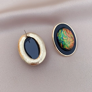 Detail view showing front and back of vintage geometric oval stud earrings with gold trim