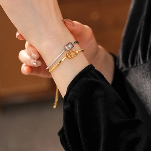 Close-up of elegant 18k gold plated chain bracelets with zircons on a model's wrist