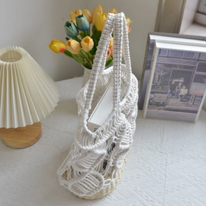 Detail of white macrame bucket bag with straw base in a stylish interior setting