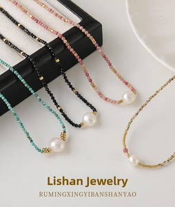 Detailed shot of bead necklaces with turquoise, black, and pink stones with white pearls